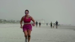 Mujer se ejercita en una playa de la Florida.