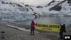 Fotografía cedida hoy, martes 16 de julio de 2013, donde se ve al cantante español Alejandro Sanz (i) sosteniendo una pancarta en la zona en la zona de Kulusuk (Groenlandia).
