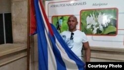 Maikel Herrera Bones posa con una bandera cubana. (Foto: Cortesía de la familia)