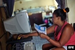 Una mujer intenta conectarse a internet en su casa en La Habana.