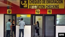  Dos mujeres chequean su pasaportes en las cabinas de emigración del aeropuerto Internacional José Martí hoy, martes 16 de octubre de 2012, en La Habana (Cuba). Cuba anunció hoy la eliminación de los permisos de salida para viajar al extranjero y dejará s