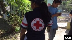 Una asistente de la Cruz Roja de Costa Rica ayuda a migrantes cubanos en un albergue temporal de La Cruz. Foto: Claudio Castillo, Martí Noticias.