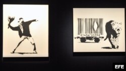 Obras del grafitero Banksy "Love is in the Air" (2002) (i) y "Leopard and Barcode" (2002), (c), y Bomb Hugger" (d), expuestas en la casa de subastas Bonham de Londres, Inglaterra.
