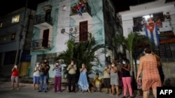 Vecinos de un barrio habanero aplauden el 30 de marzo a médicos y enfermeras que combaten el coronavirus en la capital de Cuba (Foto: Yamil Lage/AFP).