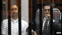 El expresidente egipcio Hosni Mubarak (d) y su hijo Gamal (i), fotografiados en la celda del tribunal mientras la corte dicta sentencia en El Cairo (Egipto) hoy, miércoles 21 de mayo de 2014.