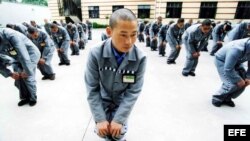 Prisioneros chinos realizan ejercicios en una prisión C