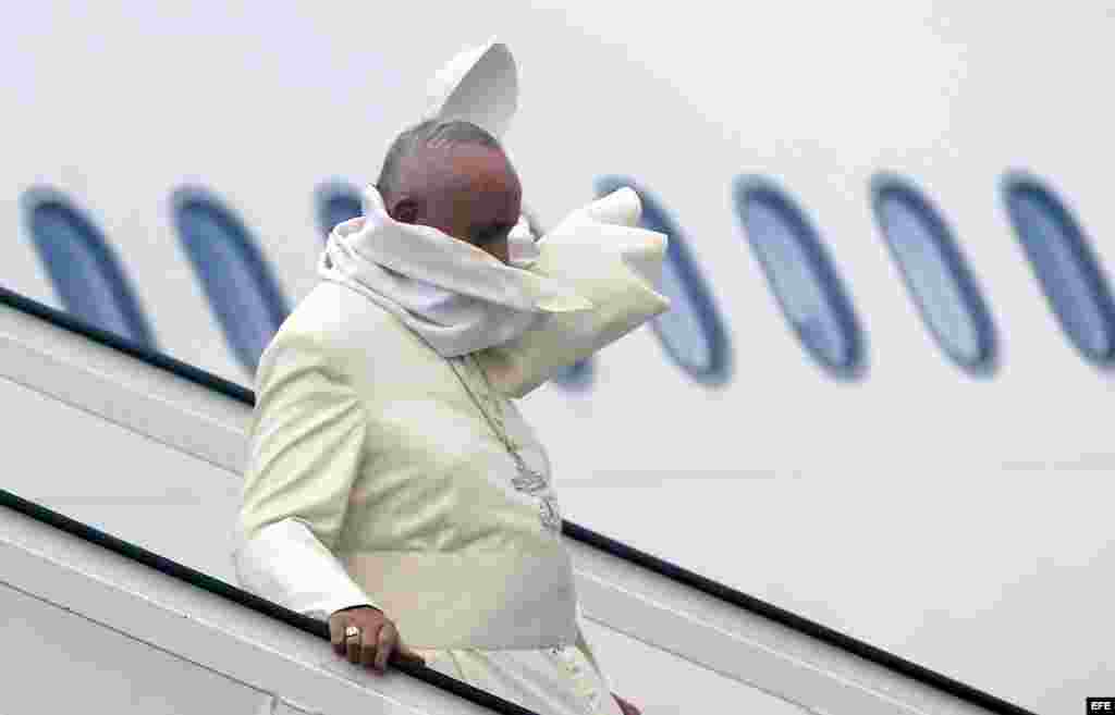 El viento juguetea con la capa del Papa Francisco, mientras desciende de las escalerillas del avión que lo condujo a La Habana.