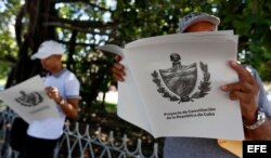 Dos personas leen el Proyecto de Constitución de la República de Cuba