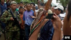Un grupo de indígenas rodea a un guerrillero de las FARC en la vía que conduce de El Palo a Toribío.