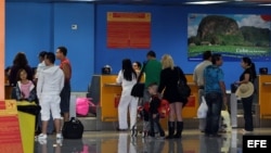 Varias personas chequean sus documentos para abordar un vuelo hacia Miami (EEUIU), en la Terminal 2 del aeropuerto José Martí de La Habana (Cuba).