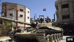 Fotografía facilitada por la agencia de noticias siria SANA que muestra a varios soldados de la Armada siria sobre un tanque, mientras patrullan las calles de la población de Shabaa, en Damasco (Siria), hoy, martes 17 de septiembre de 2013