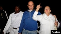 Héctor Maseda (centro) camina junto a su esposa, Laura Pollán (derecha) —quien hace el gesto de la «L»—, y Berta Soler (izquierda), desafían a las turbas procastristas, en La Habana, el 12 de febrero de 2011.