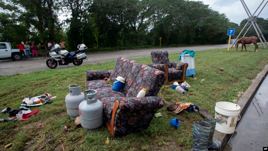 Muebles y objetos de una casa inundada por lluvias torrenciales, se secan a la intemperie en una carretera en La Habana, Cuba, el miércoles 13 de diciembre de 2023. (Foto AP/Ismael Francisco)