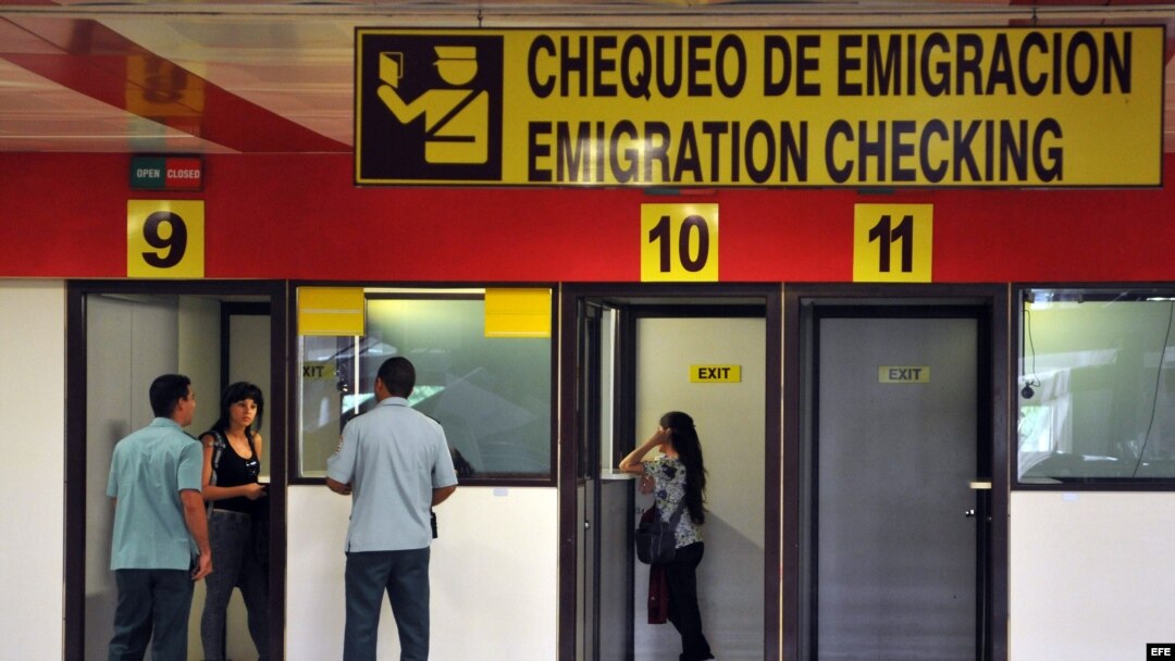 Dos mujeres chequean sus pasaportes en las cabinas de emigración del aeropuerto José Martí, en La Habana.