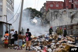Bomberos intentan apagar una fogata de basura en La Habana el 19 de junio de 2026. YAMIL LAGE / AFP