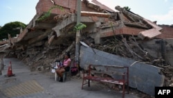 Una vendedora de café junto a un edificio derrumbado en Catia La Mar, estado de La Guaira, Venezuela, el 16 de julio de 2026.