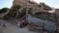 Una vendedora de café junto a un edificio derrumbado en Catia La Mar, estado de La Guaira, Venezuela, el 16 de julio de 2026.