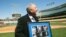 Tommy John muestra la foto de la operación a la que fue sometido, durante un homenaje de los Dodgers en 2014.