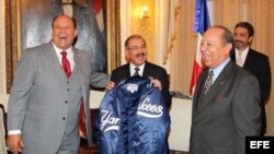 El presidente de República Dominicana, Danilo Medina (c), recibe una chaqueta del equipo de béisbol los Yankees de Nueva York de manos del fundador y presidente del Salón de la Fama de Béisbol Latino, Robert Weil (d), y del vicepresidente del equipo, Féli