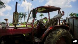 Un trabajador agrícola espera en su tractor sin combustible en Guanajay, en mayo de 2023. (Foto AP/Ramon Espinosa)