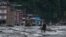 Un residente camina por una calle cubierta de barro tras unas inundaciones repentinas y un deslizamiento de tierra en Devighat, en el distrito nepalí de Nuwakot, el 26 de agosto de 2026.