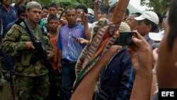 Un grupo de indígenas rodea a un guerrillero de las FARC en la vía que conduce de El Palo a Toribío.