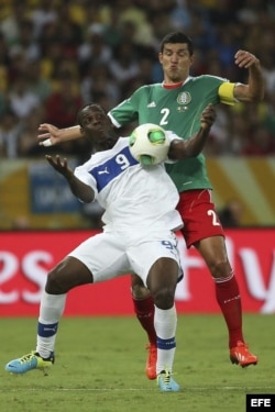 El delantero italiano Mario Balotelli (i) lucha por el balón con el defensa mexicano Francisco Rodríguez (d) durante el partido del Grupo A de la Copa de Confederaciones 2013.