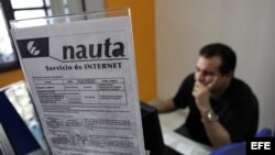 Varias personas se conectan a internet desde una sala de navegaciión en La Habana
