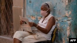 Una mujer lee el periódico en La Habana (Yamil Lage/AFP).