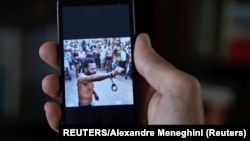 Un hombre que no quiso ser identificado muestra en su teléfono al rapero contestatario Maykel Castillo Pérez "El Osorbo", cuando resistió arresto en el barrio San Isidro, de La Habana, el 4 de abril de 2021. (REUTERS/Alexandre Meneghini).