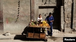Foto Archivo. Carretillero arregla su puesto de venta en una calle de Cuba.