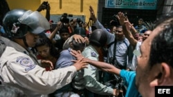 Un cordón policial separa al grupo de seguidores del opositor venezolano Leopoldo López, y otro grupo oficialista.