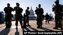 Miembros de la Guardia Nacional de Michigan y la Policía del Capitolio de EE.UU. vigilan los terrenos del Capitolio el 3 de marzo de 2021.