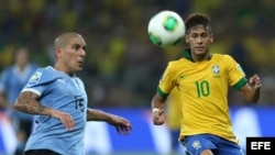 El delantero de la selección de Brasil, Neymar da Silva (d), lucha el balón con Maximiliano Pereira, defensa de Uruguay.