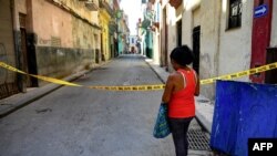 Una mujer entra a un barrio cerrado por coronavirus en La Habana (YAMIL LAGE / AFP)