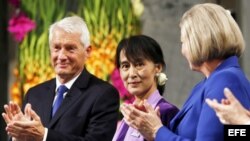 La opositora birmana Aung San Suu Kyi en el centro, es aplaudida por los miembros del Comité del Nobel Thorbjoern Jagland a la izquierda y Kaci Kullmann Five a la derecha tras pronunciar su discurso del Nobel de la Paz en el ayuntamiento de Oslo, Noruega,