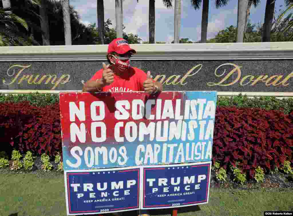 El cubano Orlando Bacallao muestra un gran cartel con lemas anticomunistas durante la visita este viernes del presidente Donald Trump al Sur de Florida.