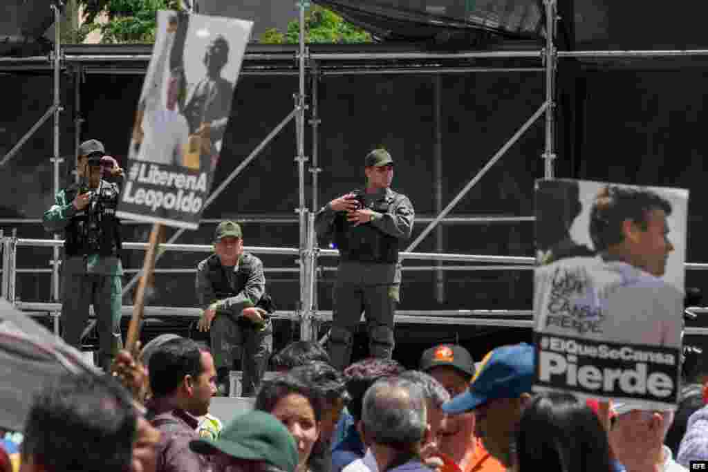 Miembros de las Fuerzas Armadas Bolivarianas de Venezuela (FANB) vigilan frente a un grupo de personas que sostienen afiches del líder opositor venezolano Leopoldo López el 4 de septiembre de 2015, afuera del Palacio de Justicia en Caracas (Venezuela)
