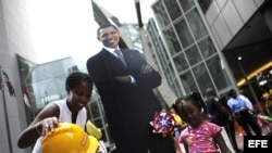 Unos niños posan junto a una imagen del presidente estadounidense, Barack Obama, en el centro de Charlotte, Carolina del Norte, (EEUU). 