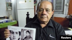 Raúl Borges sostiene fotos de su hijo Ernesto Borges en enero de 2015. (REUTERS/David Adams).