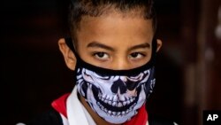 Camino a la escuela, una estudiante de primaria en La Habana viste una máscara contra el coronavirus. (AP/Ramon Espinosa)