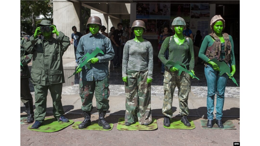 Un grupo de estudiantes de la Universidad Experimental de Arte (UNEARTE) protestan caracterizados como militares en contra de la represión militar a estudiantes y civiles, en Caracas (Venezuela).