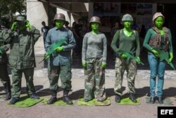 Un grupo de estudiantes de la Universidad Experimental de Arte (UNEARTE) protestan caracterizados como militares en contra de la represión militar a estudiantes y civiles, en Caracas (Venezuela).