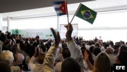 Médicos extranjeros escuchan a Dilma Rousseff, el 22 de octubre de 2013, durante la sanción del proyecto de ley que reglamenta la contratación de médicos de fuera del país para atender áreas que carecían de servicios de salud,en el palacio presidencial de