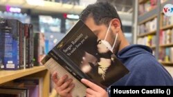 Un hombre hojea un libro del escritor Sergio Ramírez