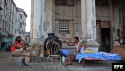  Dos hombres cuya vivienda fue severamente afectada por el huracán Irma conversan junto a sus pertenencias el jueves 21 de septiembre de 2017, en el malecón de La Habana (Cuba). 