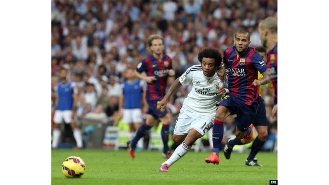 El defensa brasileño del Real Madrid Marcelo Vieira (i) lucha la posición con su compatriota del FC Barcelona Dani Alves.