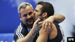 Danell Leyva besa a su entrenador y padrastro Yin Álvarez tras ganar el oro en la prueba de paralelas del campeonato Mundial de Gimnasia Artística el 16 de octubre de 2011, en Tokio, Japón.