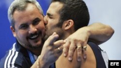 Danell Leyva besa a su entrenador y padrastro Yin Álvarez tras ganar el oro en la prueba de paralelas del campeonato Mundial de Gimnasia Artística el 16 de octubre de 2011, en Tokio, Japón.