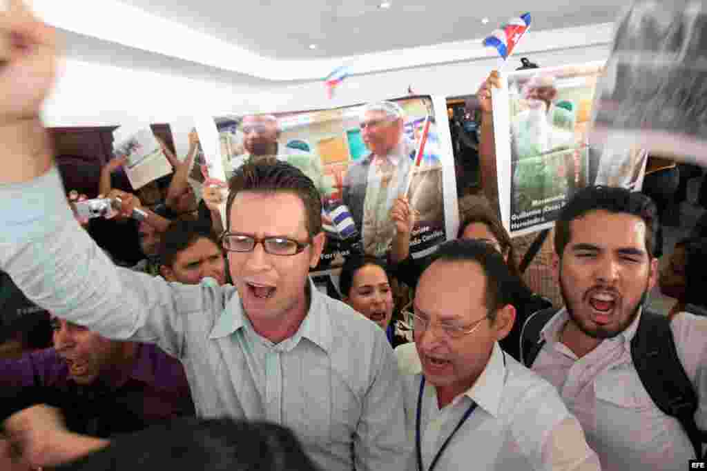 Los manifestantes oficialistas enarbolan pancartas con las imágenes de Guillermo Fariñas y Luis Posada Carriles.
